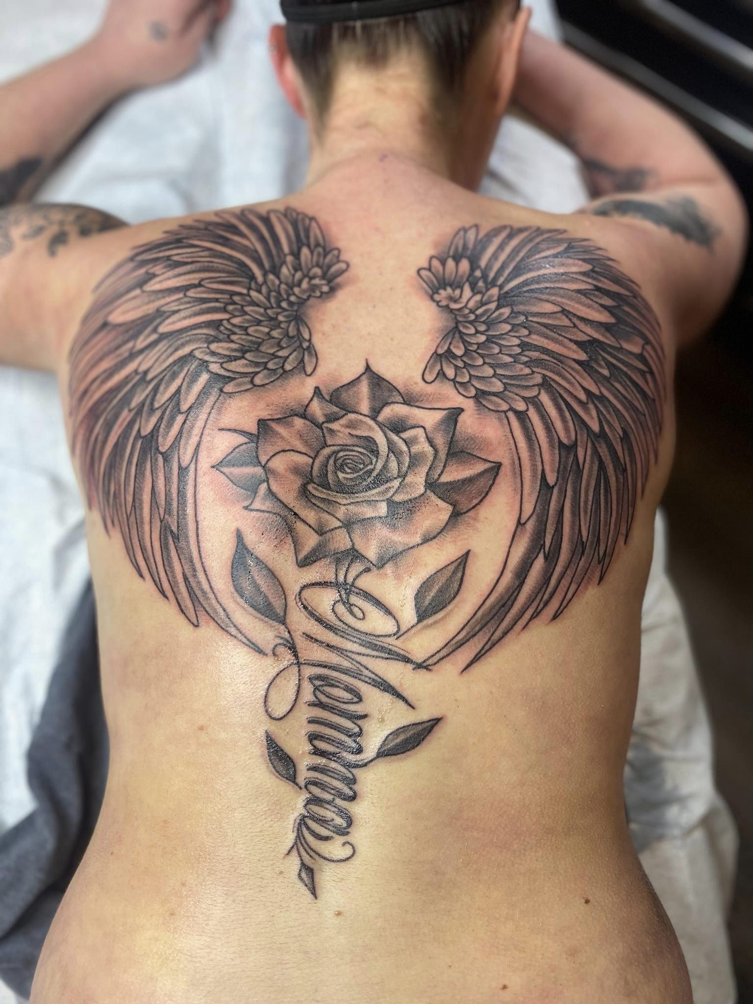 angel wings tattoo with flowers